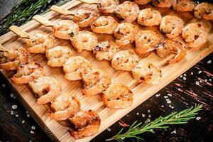 Grilled shrimp on a wooden cutting board. photo
