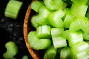 Pieces of fresh celery in a wooden plate. photo