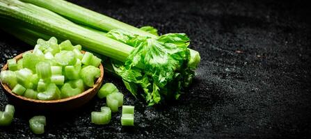 Pieces of celery in a wooden plate on the table. photo