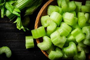 Sliced fresh celery. On a dark wooden background. photo