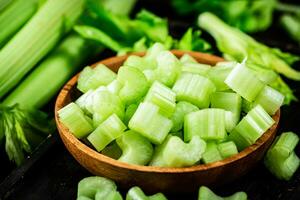 Sliced fresh celery. On a dark wooden background. photo