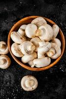 Fresh mushrooms in a wooden plate. photo