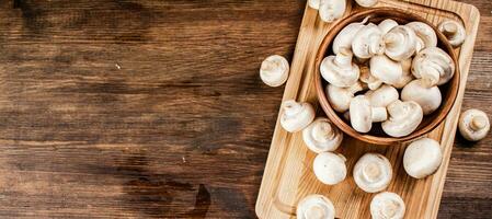 Mushrooms in a bowl on a cutting board. photo