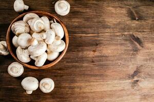 A wooden plate full of fresh mushrooms. photo