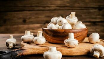 Mushrooms in a bowl on a cutting board. photo