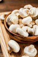 Mushrooms in a bowl on a cutting board. photo