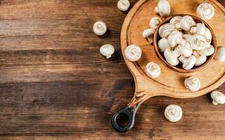 Mushrooms in a bowl on a cutting board. photo
