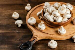 Mushrooms in a bowl on a cutting board. photo