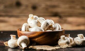 A wooden plate full of fresh mushrooms. photo