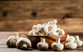 A wooden plate full of fresh mushrooms. photo