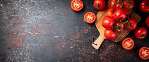 Fresco Tomates en un de madera corte tablero. foto