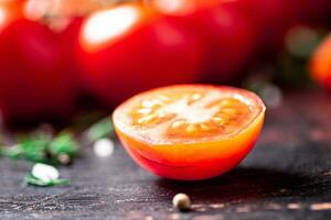 Tomatoes on a branch with pieces of greens and spices. photo