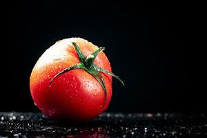 One ripe tomato on the table. photo