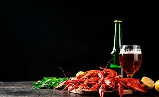 hervido cangrejo de río con un vaso de cerveza y limón. foto