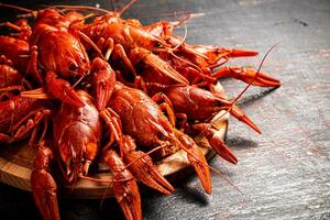 Boiled crayfish on a round cutting board. photo