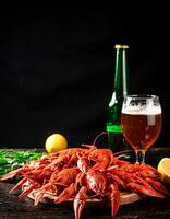Boiled crayfish with a glass of beer and lemon. photo