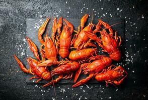 Boiled crayfish on a stone board with salt. photo