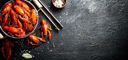 Boiled crayfish in a colander on a stone board. photo