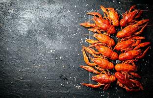 Boiled crayfish on a stone board with salt. photo