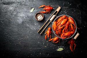 Boiled crayfish in a colander on a stone board. photo