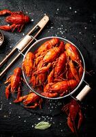 Boiled crayfish in a colander on a stone board. photo