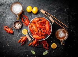 Boiled crayfish in a colander on a stone board. photo
