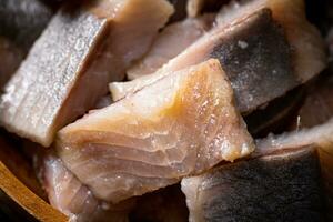 Delicious pieces of salted herring on a stone board. photo