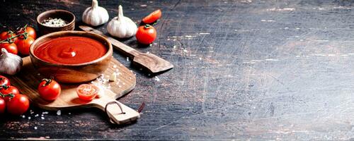 Tomato sauce on a wooden cutting board with garlic and spices. photo