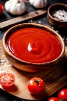 Tomato sauce on a wooden cutting board with garlic and spices. photo