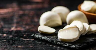 Pieces of mozzarella cheese on a stone board. photo