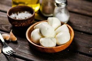Mozzarella cheese with garlic. On a wooden background. photo