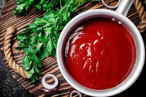 Tomato sauce with parsley and onion rings on the tray. photo