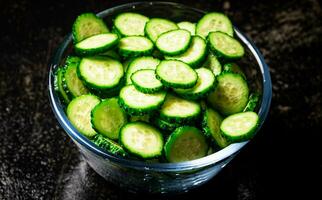 Full glass bowl of chopped fresh cucumbers. photo