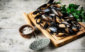 un manojo de hervido mejillones en un de madera corte tablero. foto