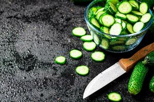 Full glass bowl of chopped fresh cucumbers. photo