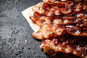 Pieces of fried bacon on paper. photo