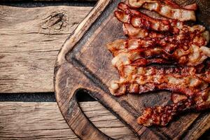 Fried bacon on a cutting board. photo