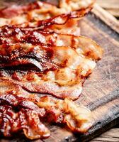 Fried bacon on a cutting board. photo