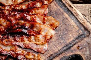 Fried bacon on a cutting board. photo