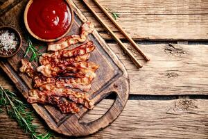 Pieces of fried bacon with tomato sauce. photo