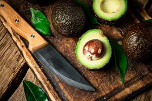 Halves of fresh avocado on a cutting board. photo