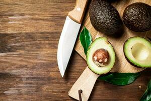 Halves of fresh avocado on a cutting board. photo