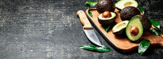 Fresh avocado with foliage on a cutting board. photo