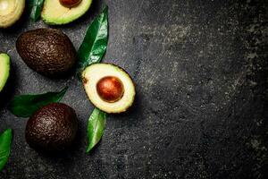 Fresh avocado with leaves. On a black background. photo