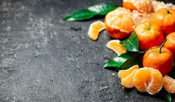 Ripe tangerines with foliage. On a black background. photo