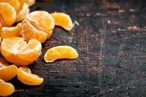 Peeled tangerines. Against a dark background. photo