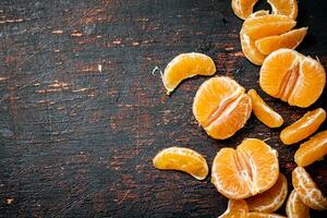 Peeled tangerines. Against a dark background. photo