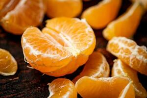 Peeled tangerines. Against a dark background. photo