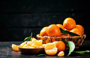 Pieces of fresh tangerines on a plate with leaves. photo