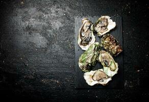 Raw oysters on a stone board. photo